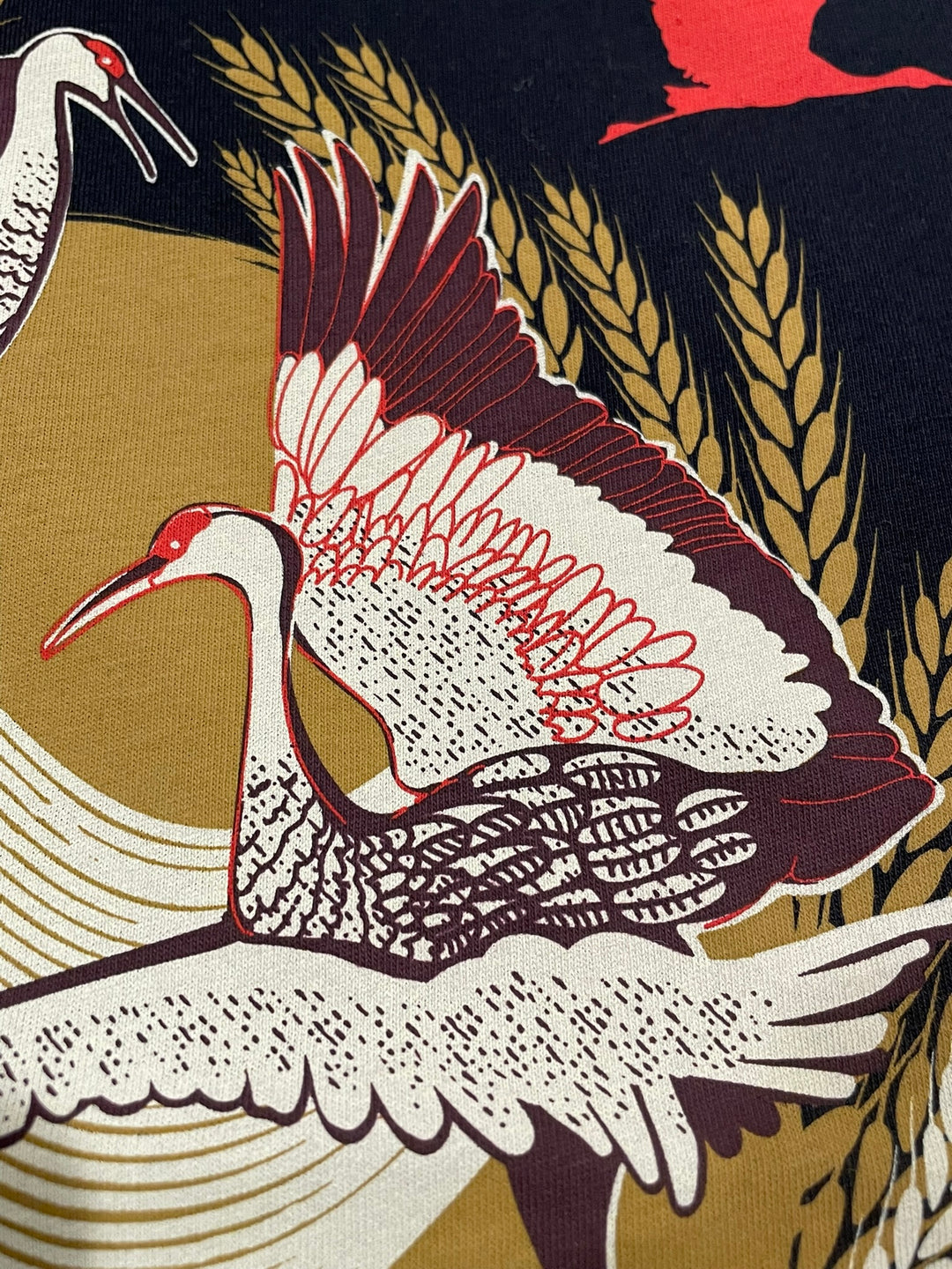 Decorative fabric with crane design on a gold and black background