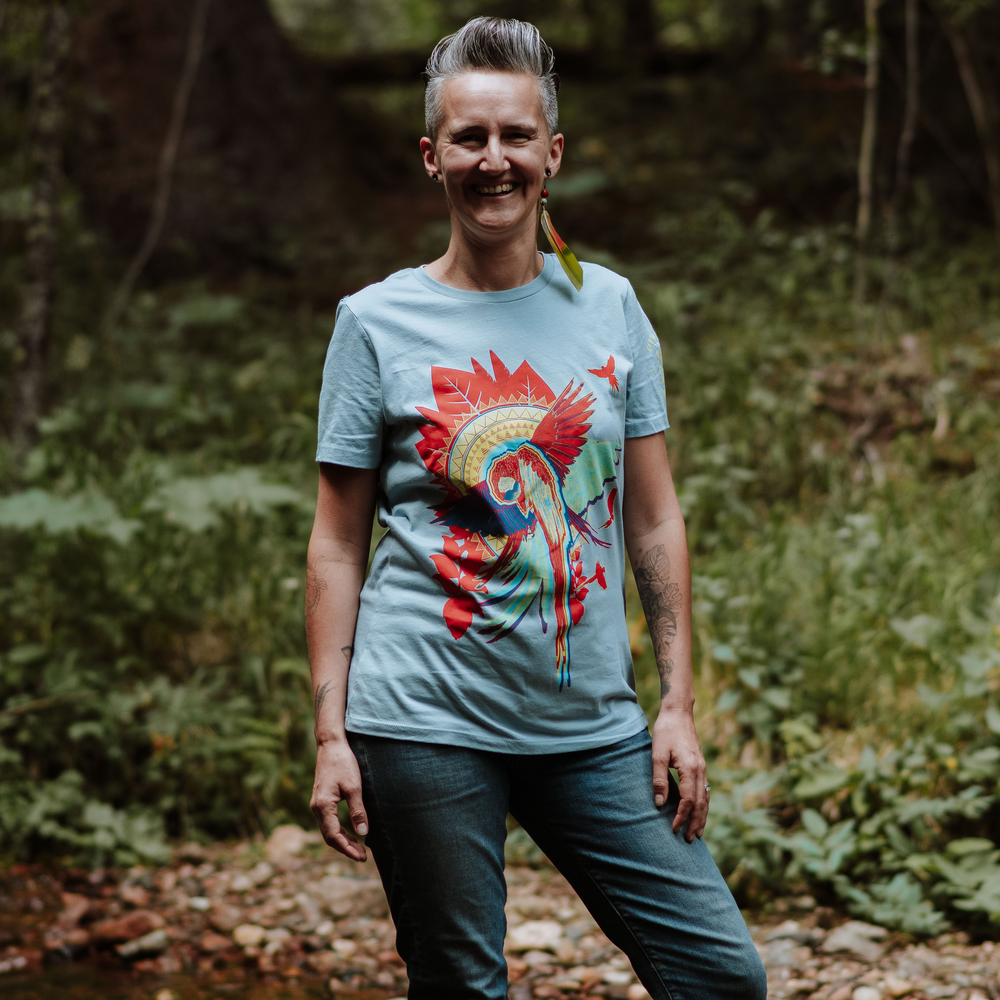 Woman wearing a vintage denim t-shirt with a colorful design in a forest setting