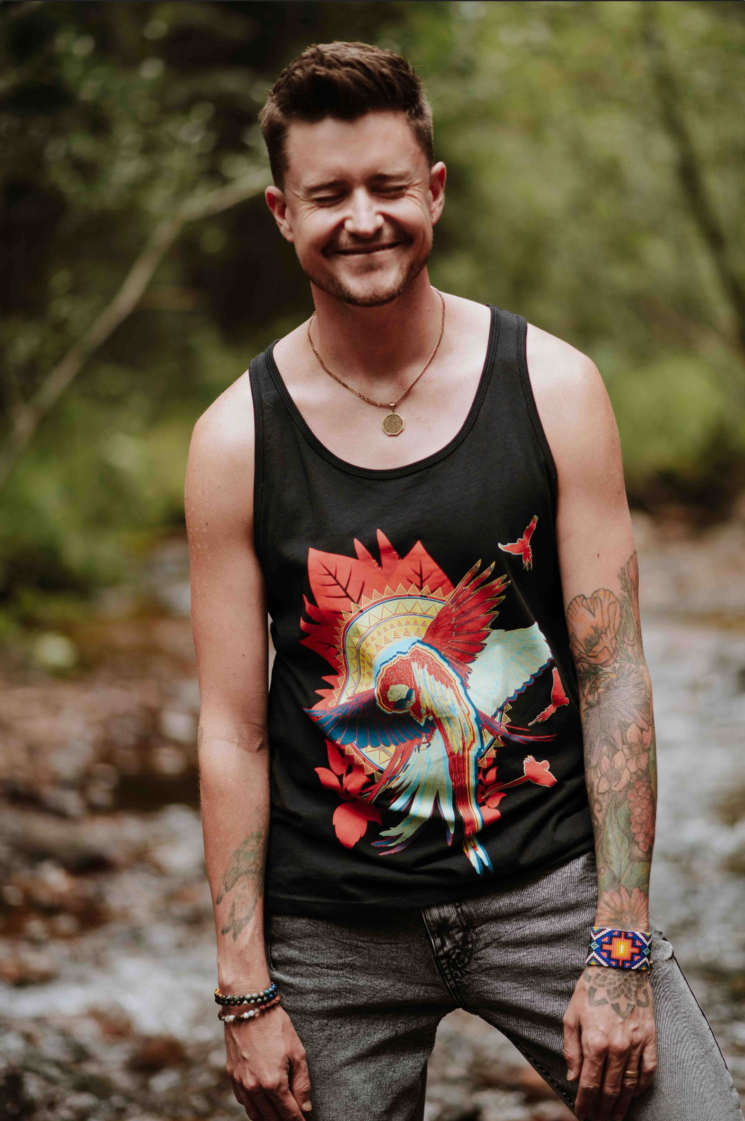 Man wearing a tank top with a colorful macaw design in a natural setting
