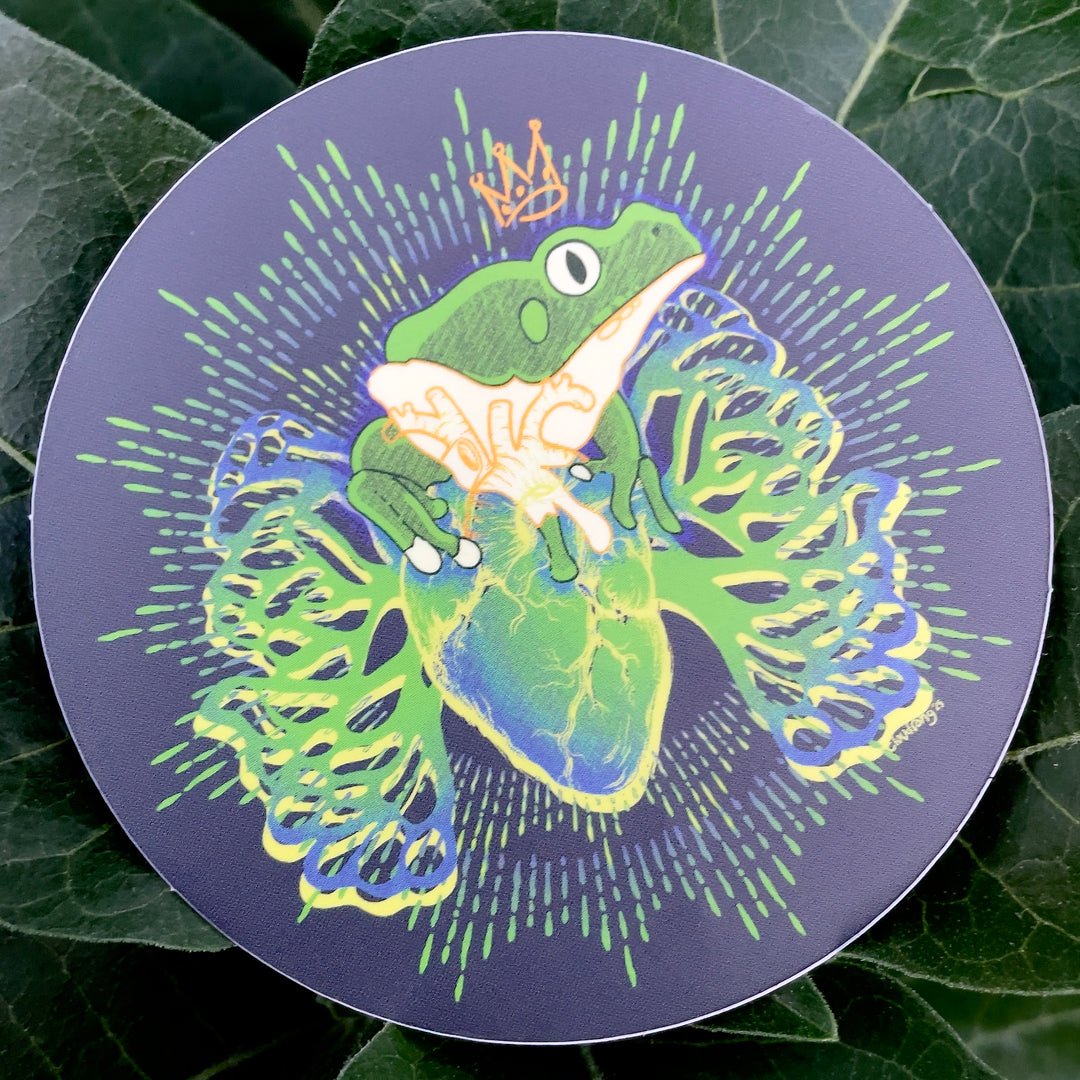 Circular sticker with a frog design on a leafy background