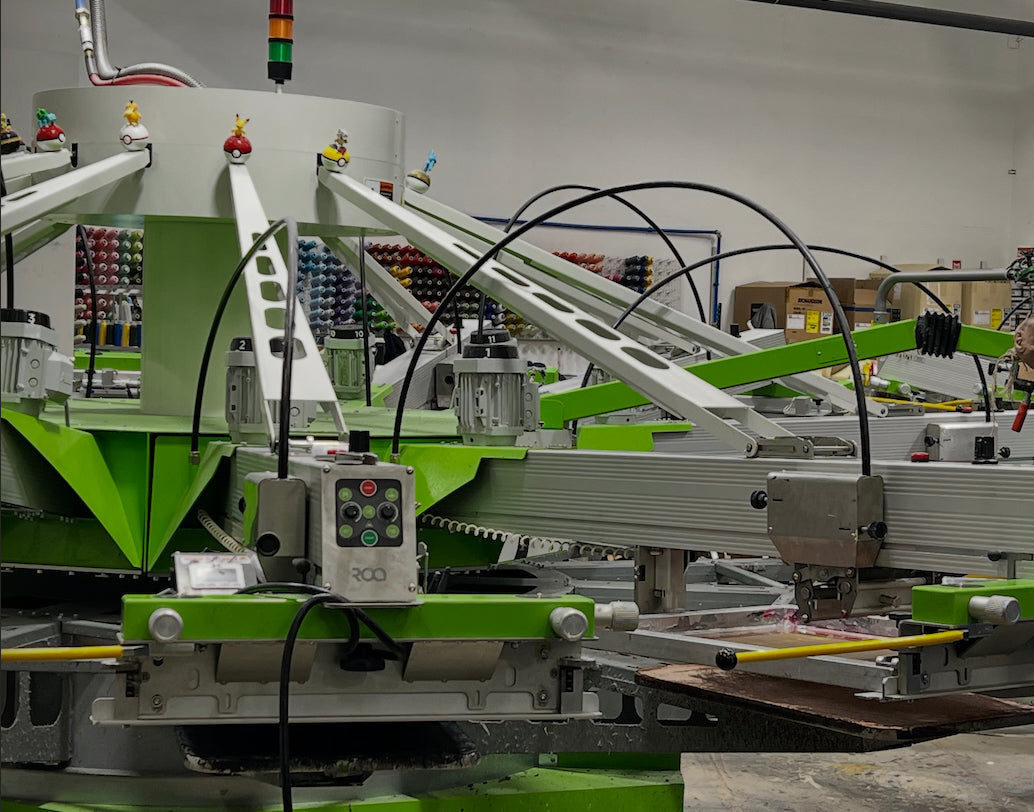 Industrial screen printing machine with green and gray components in a warehouse setting