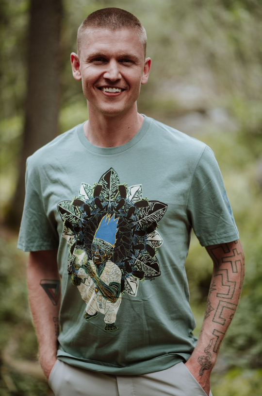 Man wearing a green t-shirt with a graphic design in a forest setting